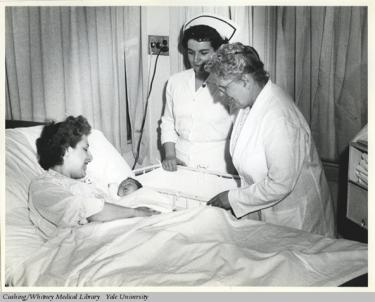 Dr. Edith B. Jackson speaking to a new mother and her baby.